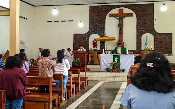 Jemaat berdoa bersama menghadap altar gereja