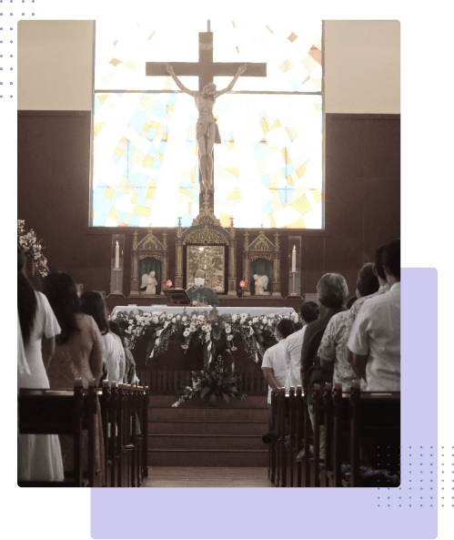 Umat mengikuti misa minggu menghadap altar dengan salib kaca patri